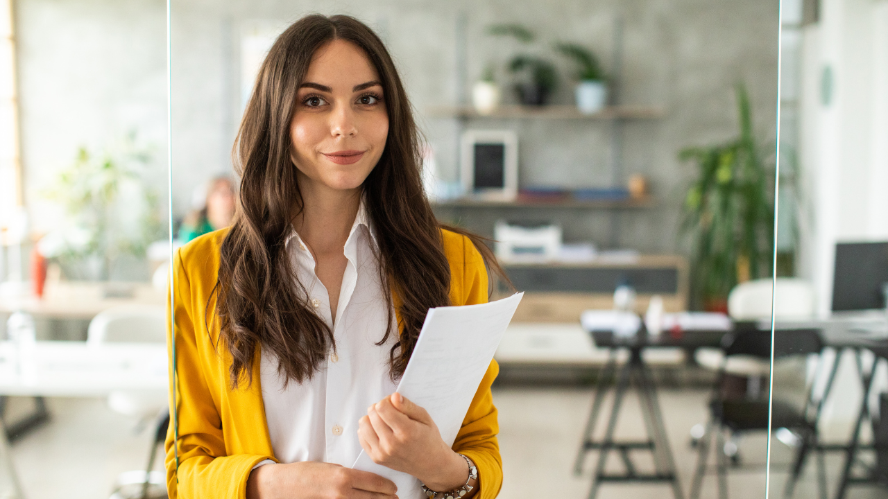 A business professional smiling while holding a stack of papers | Scott Legal, P.C. A business professional smiling while holding a stack of papers