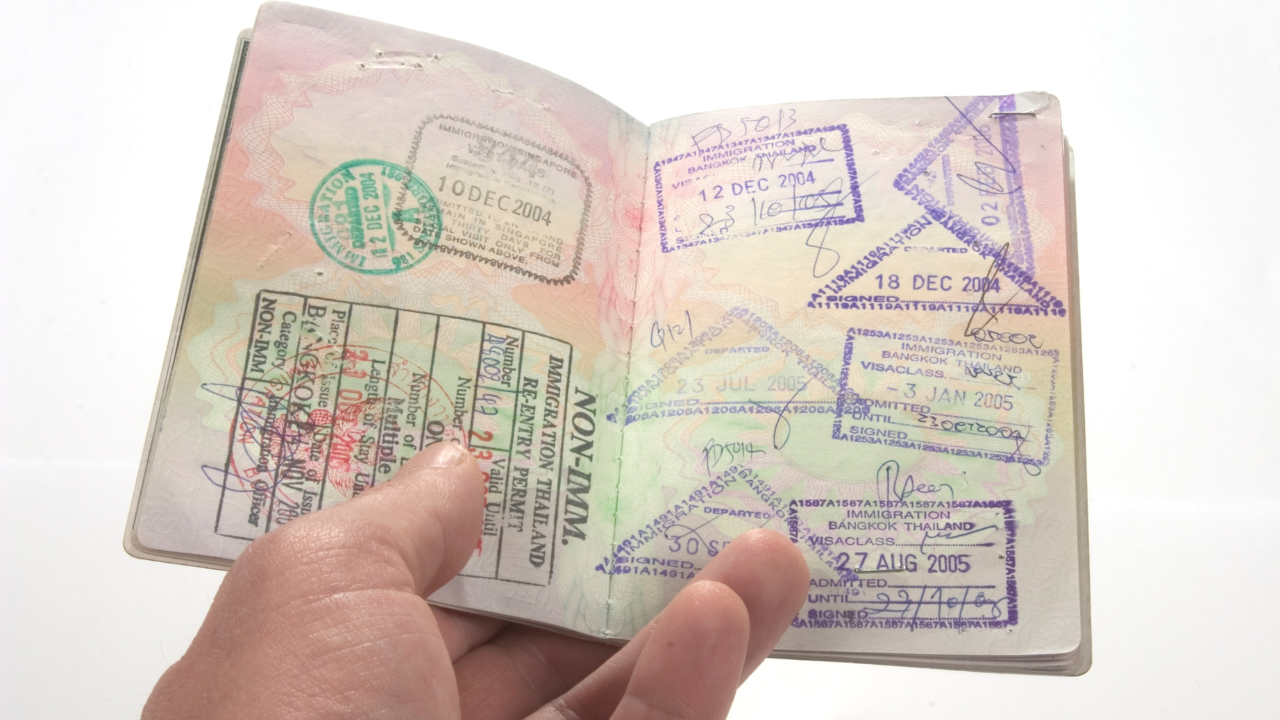 A bunch of visas and stamps in a passport | Scott Legal, P.C. A bunch of visas and stamps in a passport