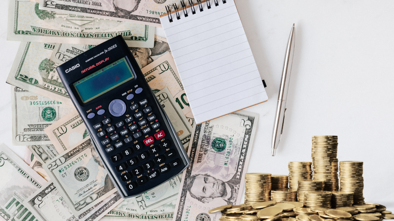 money, a calculator a pen and notepad on a desk | Scott Legal, P.C. money, a calculator a pen and notepad on a desk