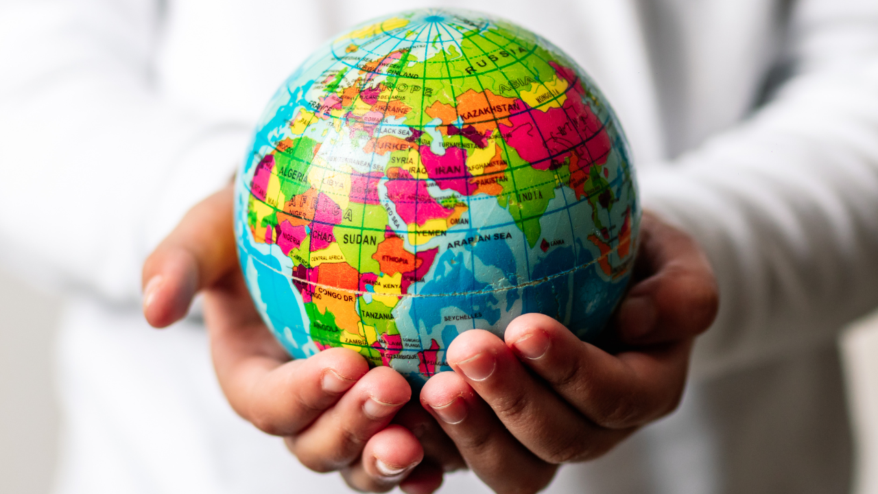 A hand holding a globe | Scott Legal, P.C. A hand holding a globe