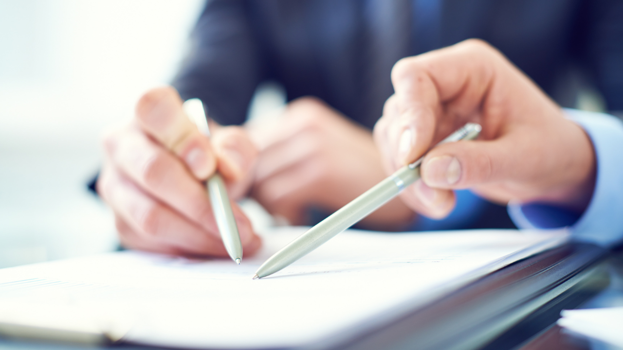 Two individuals looking over a collection of documents | Scott Legal, P.C. Two individuals looking over a collection of documents