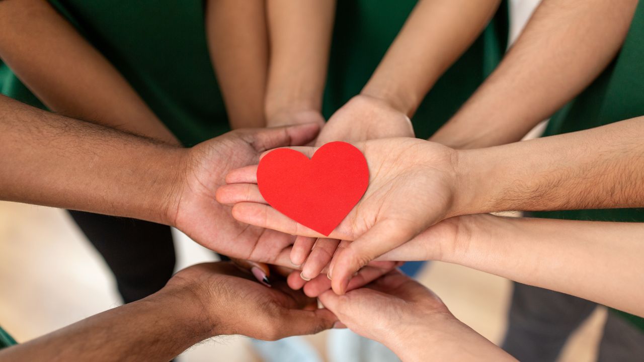 Humanitarian hands joined in solidarity while holding a heart | Scott Legal, P.C. Humanitarian hands joined in solidarity while holding a heart