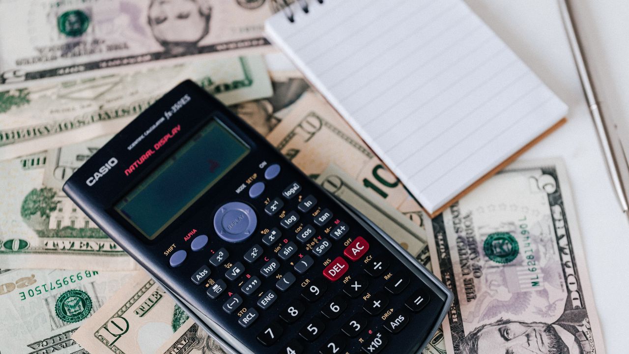 fees, a calculator and notepad with pen | Scott Legal, P.C. fees, a calculator and notepad with pen