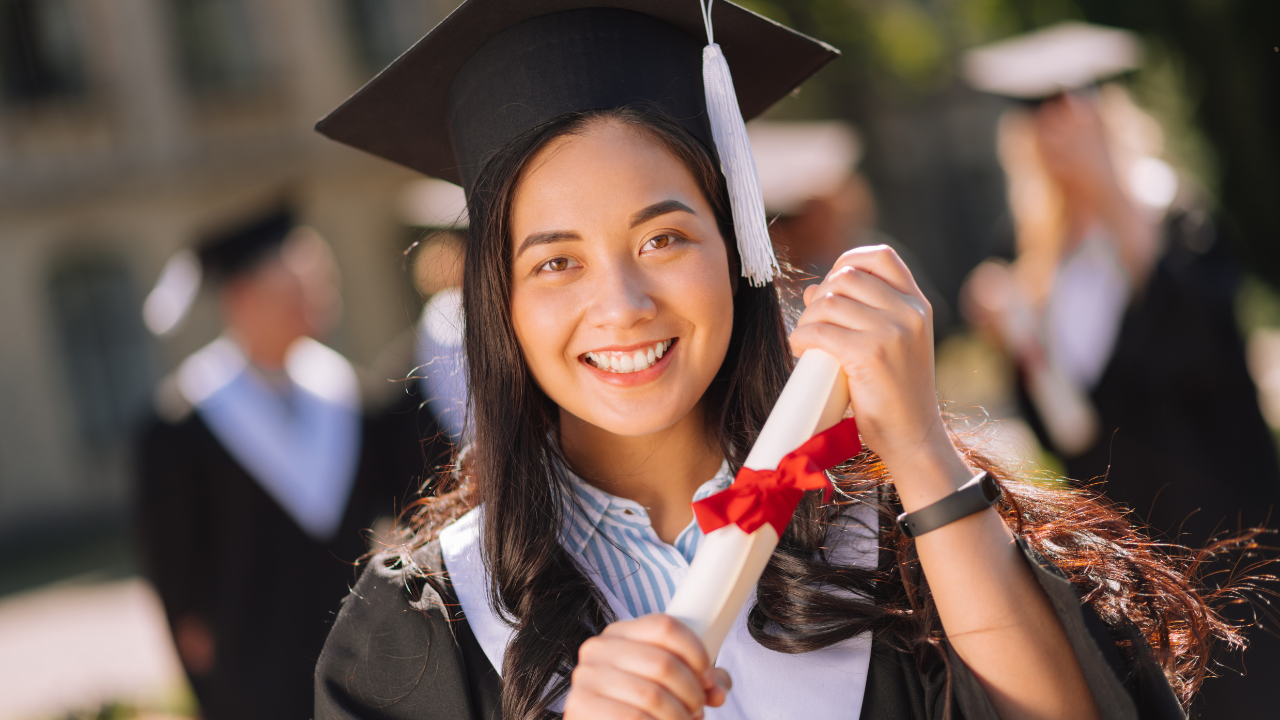 A student holding a graduate degree | Scott Legal, P.C. A student holding a graduate degree