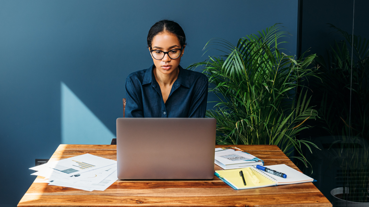 A woan working on her laptop at a desk in her home | Scott Legal, P.C. A woman working on her laptop at a desk in her home