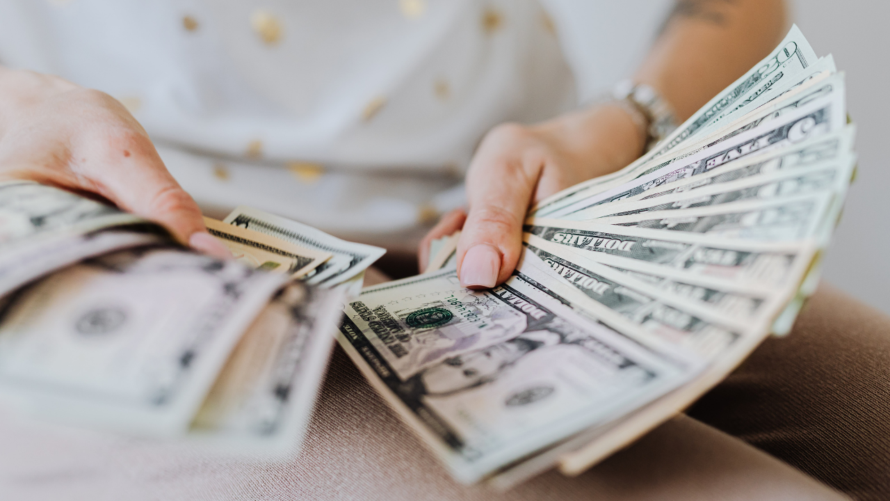 a woman holding money | Scott Legal, P.C. a woman holding money