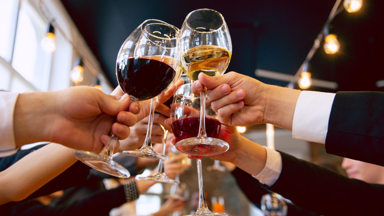 A bunch of people holding wine glasses in the air in cheers | Scott Legal, P.C. A bunch of people holding wine glasses in the air in cheers