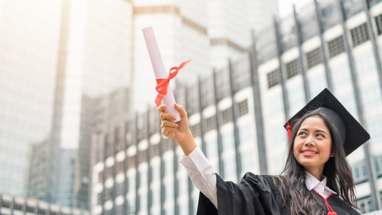 A student holding up a degree | Scott Legal, P.C. A student holding up a degree