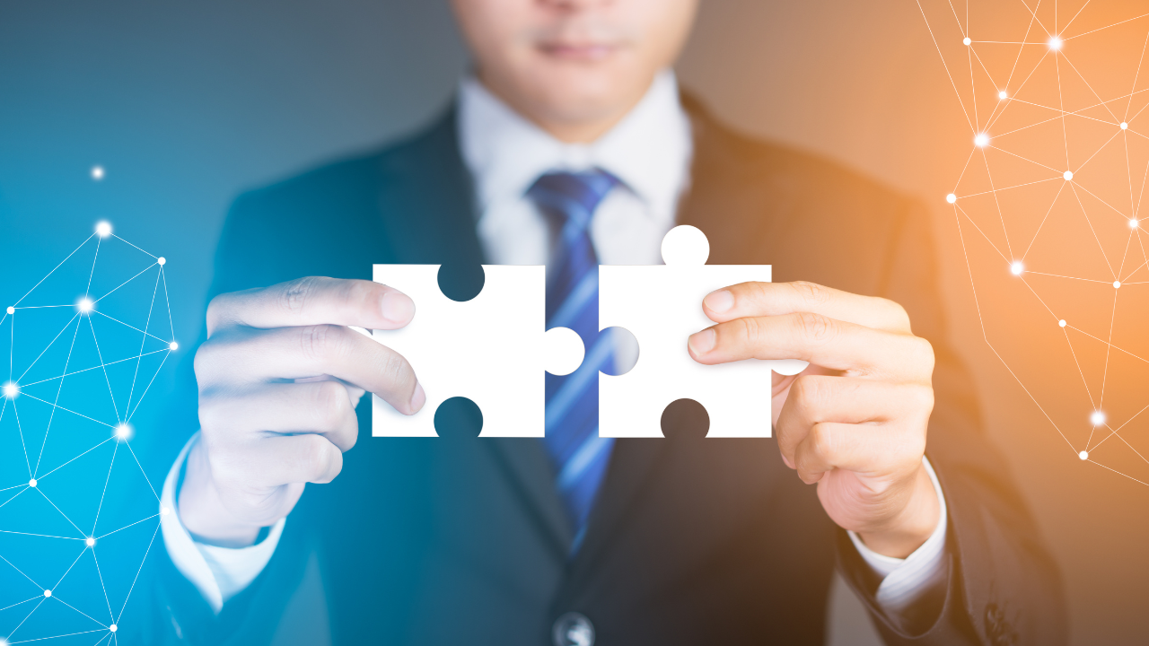 A business man holding some puzzle pieces together | Scott Legal, P.C. A business man holding some puzzle pieces together