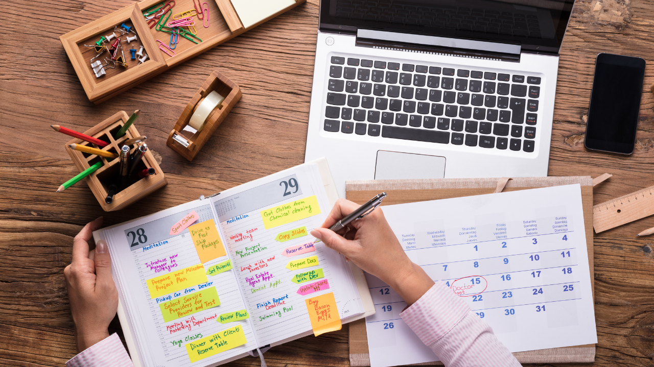 A laptop, planner, calendar, and stationary on a table. | Scott Legal, P.C. A laptop, planner, calendar, and stationary on a table.