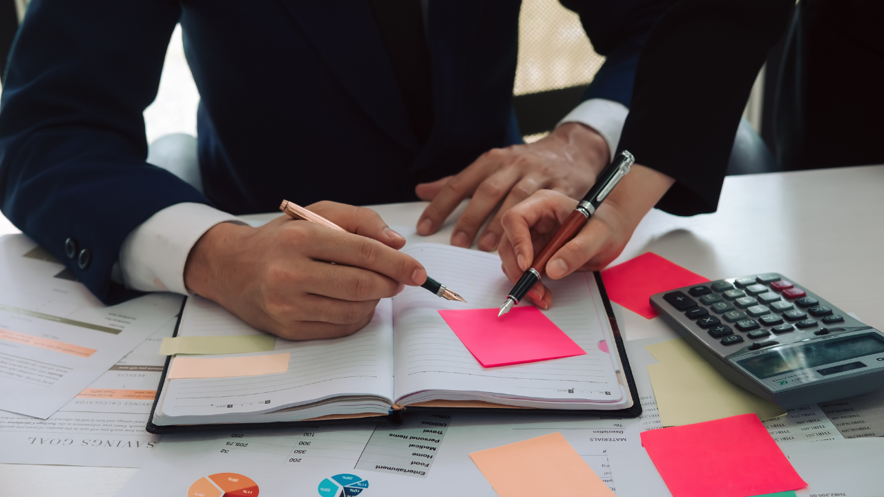 Two professionals consulting their agenda | Scott Legal, P.C. Two professionals consulting their agenda