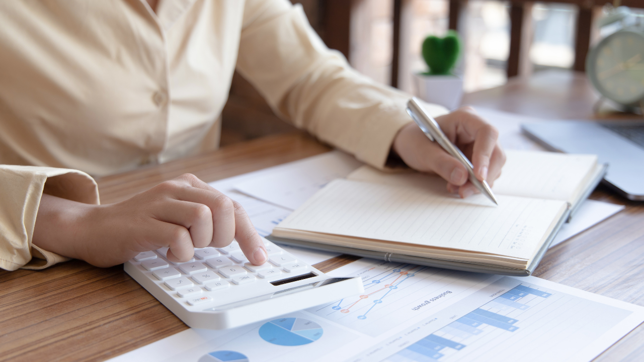 A business individual writing notes and consulting charts | Scott Legal, P.C. A business individual writing notes and consulting charts