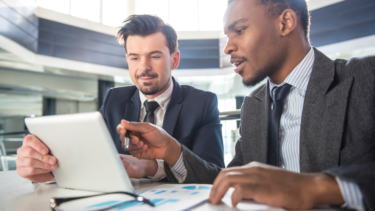 Business men having a meeting while holding a tablet | Scott Legal, P.C. Business men having a meeting while holding a tablet