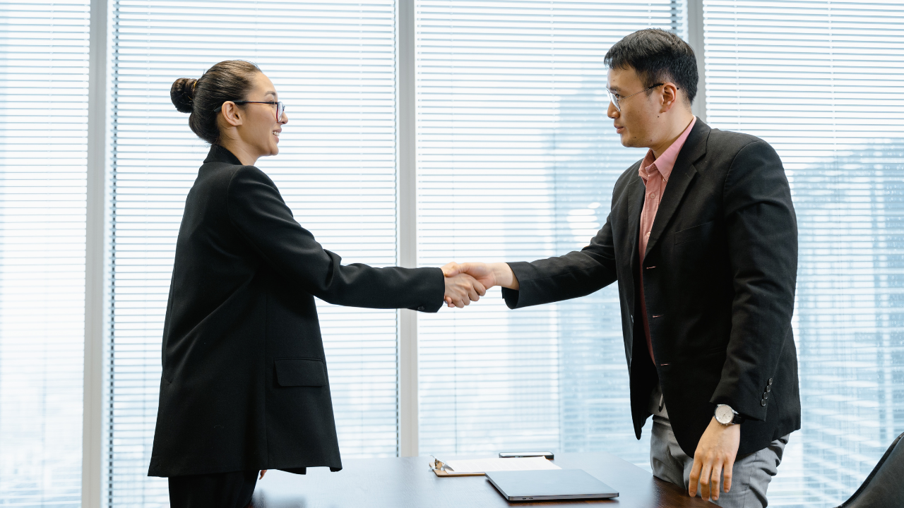 Two business men/women shaking hands | Scott Legal, P.C. Two business men/women shaking hands