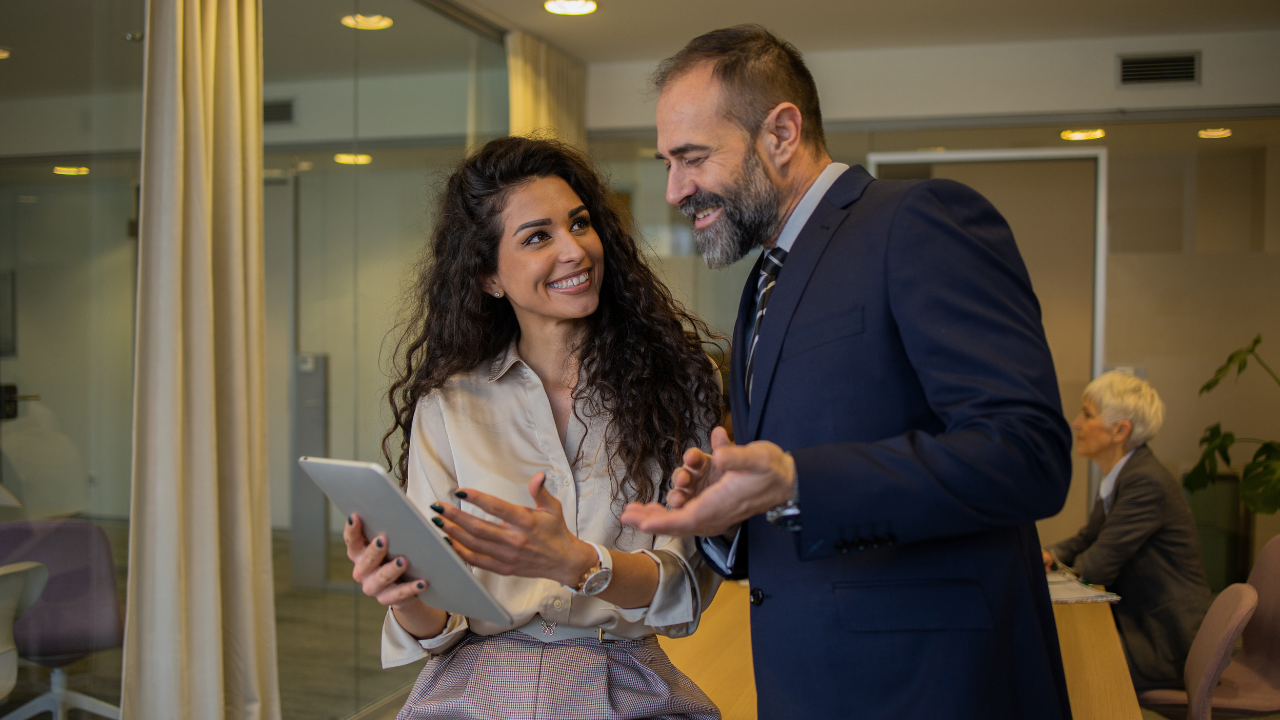 Two corporate workers consulting paper work | Scott Legal, P.C. Two corporate workers consulting paper work