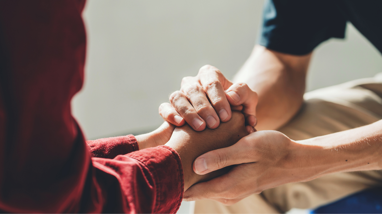 Two people holding hands in solidarity | Scott Legal, P.C. Two people holding hands in solidarity