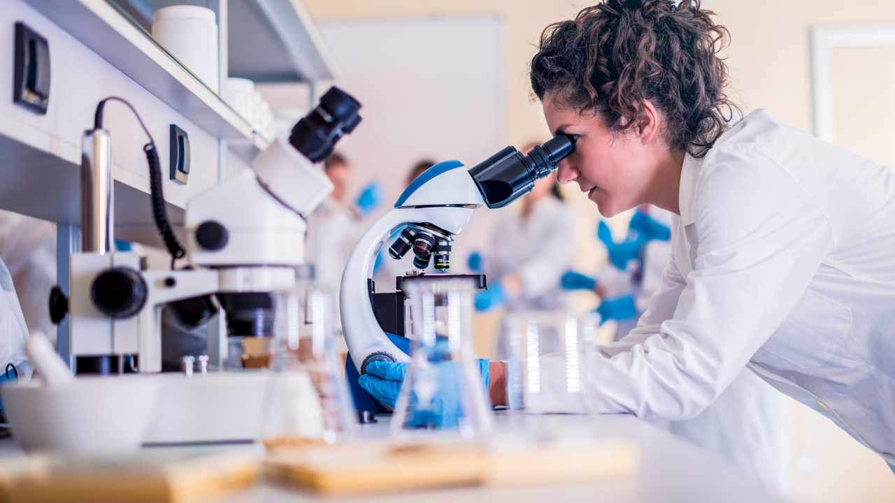 Scientist looking in a microscope | Scott Legal, P.C. Scientist looking in a microscope