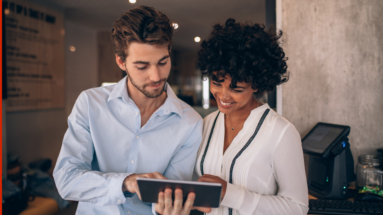 A couple of corporate workers consulting notes on a tablet | Scott Legal, P.C. A couple of corporate workers consulting notes on a tablet