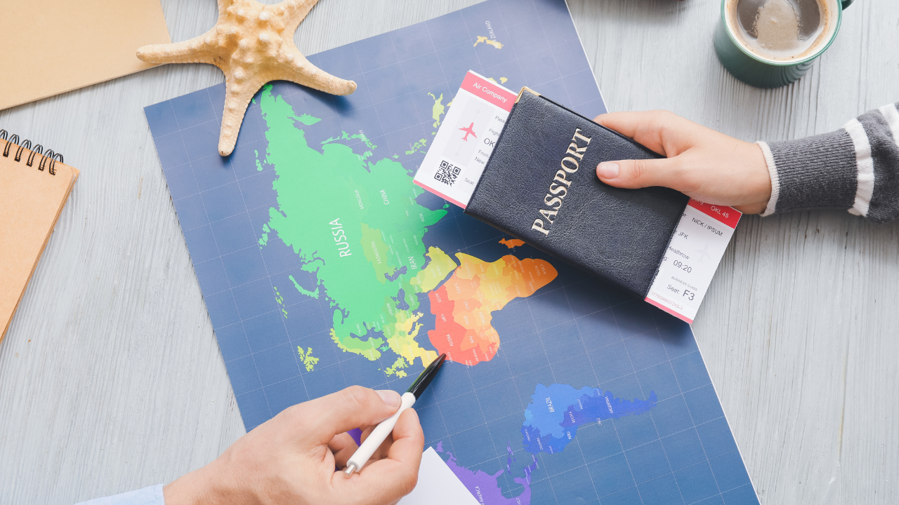 Man holding passport in hand while consulting a map | Scott Legal, P.C. Man holding passport in hand while consulting a map
