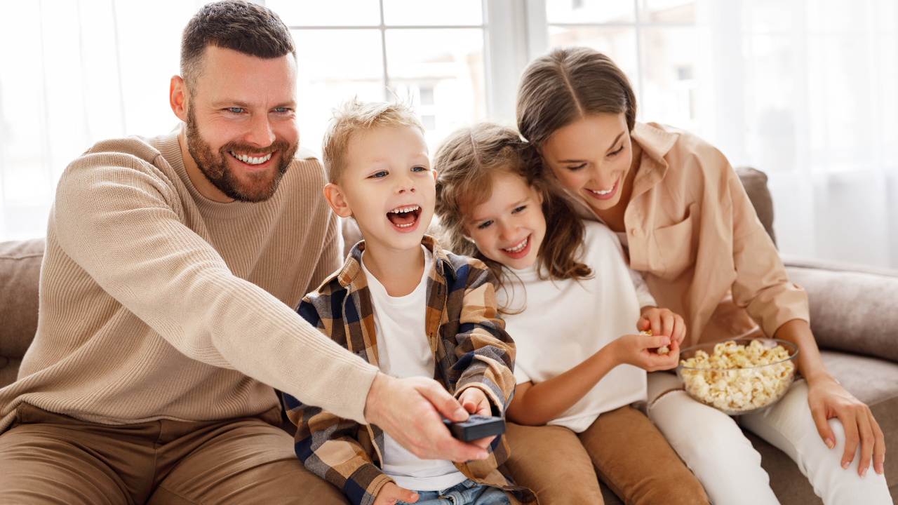 Happy family watching a movie on the couch | Scott Legal, P.C. Happy family watching a movie on the couch